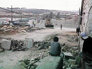 Photo: Local residents watch the bulldozer seal them in